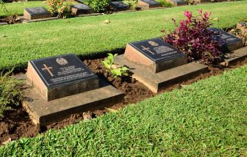Small row of name plate memorials in the ground made with bronze.